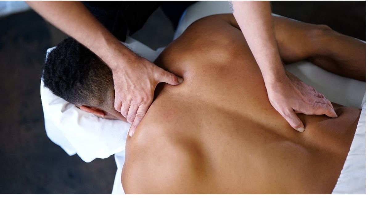 Deep tissue work across a client&rsquo;s shoulders and back
