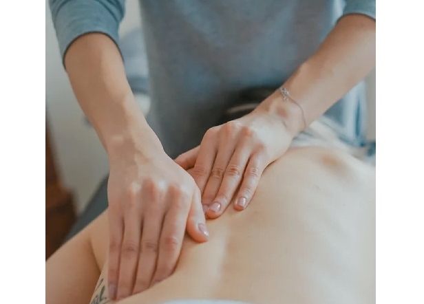 Therapist hands working across a client&rsquo;s back