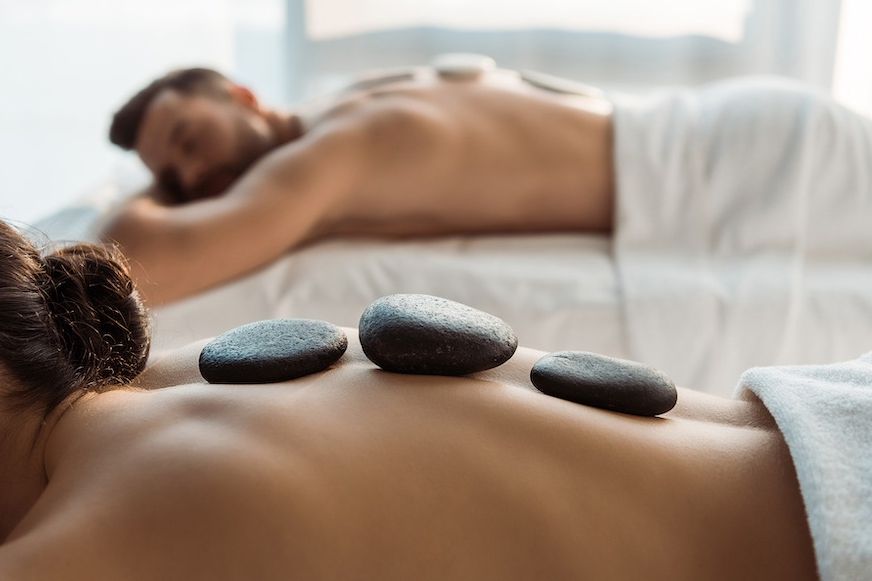 Warm stones resting along a client&rsquo;s back